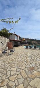 a stone patio with two chairs and a building at Apollo Romantic Sea View Villa in Kiveri