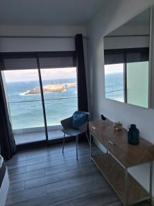 a room with a desk and a view of the ocean at KasaNova in Rabo de Peixe