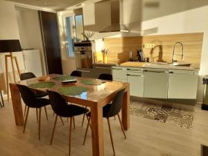 a kitchen with a wooden table and chairs in it at Gite Spa Zen 2 in Blois