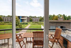a balcony with a table and chairs and a view at DUENENZEIT App Nr 5 max 4 Pers in Dierhagen