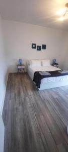 a bedroom with a bed and a wooden floor at KasaNova in Rabo de Peixe