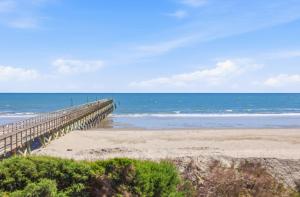 a boardwalk leading to a beach with the ocean at Tide Time Oceanfront at Sea Cabin w Pool in Myrtle Beach
