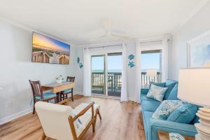 a living room with a blue couch and a table at Tide Time Oceanfront at Sea Cabin w Pool in Myrtle Beach