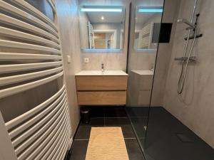 a bathroom with a sink and a mirror at Beachday II - Opkuis inbegrepen in de prijs - Garagebox inbegrepen in Nieuwpoort +17 photos
