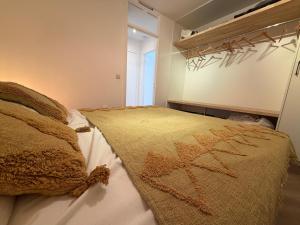 a bedroom with a bed with a blanket on it at Beachday II - Opkuis inbegrepen in de prijs - Garagebox inbegrepen in Nieuwpoort