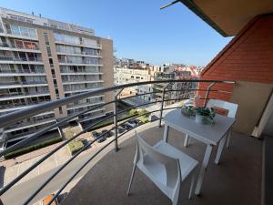 a balcony with a table and chairs on a building at Beachday II - Opkuis inbegrepen in de prijs - Garagebox inbegrepen in Nieuwpoort