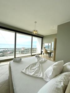 a bedroom with a large white bed with a large window at Dhermi Villa 1 in Kondaq +58 photos