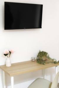 a flat screen tv on top of a wooden shelf at DOMUS Canonico in Noto