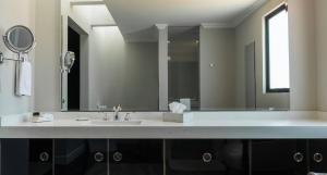ein Badezimmer mit Waschbecken und großem Spiegel in der Unterkunft Hotel Plaza 79 in San Cristóbal de las Casas