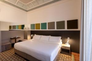 a bedroom with a large white bed in a room at Riflessi Acireale Palace Suites in Acireale