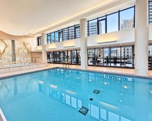 a large swimming pool in a building with windows at 2 Bedroom Condo With City Views and Free Parking in Toronto