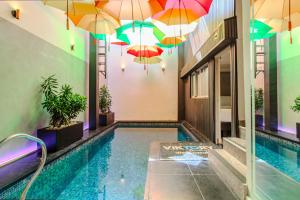 a swimming pool with umbrellas hanging over it at Viktory Boutique Hotel in Medellín