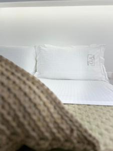 a bed with white pillows and a blanket on it at G A Suites Maisonettes in Skala in Skala