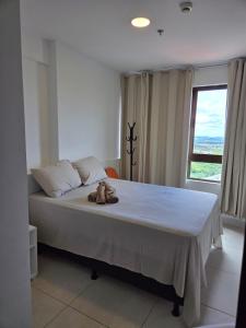 a bedroom with a bed with a teddy bear on it at Apartamento Fantástico - com estação para carros eletricos in Campina Grande