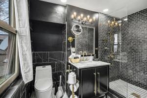 a bathroom with a toilet and a sink and a shower at Lil' Red House On Porter in Detroit +11 photos