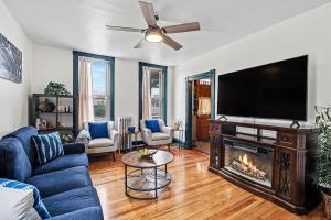 a living room with a fireplace and a flat screen tv at Lil' Red House On Porter in Detroit