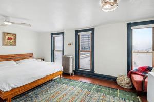 a bedroom with a bed and two windows at Lil' Red House On Porter in Detroit