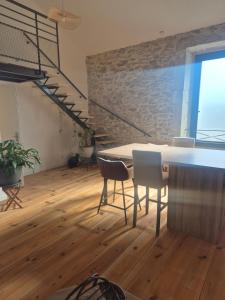 a dining room with a table and chairs and a staircase at Aigues-Vives Appartement in Aigues-Vives