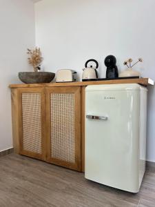 a white refrigerator next to a counter with a sink at G A Suites Maisonettes in Skala in Skala