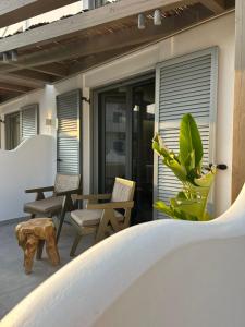 a patio with chairs and a table and a plant at G A Suites Maisonettes in Skala in Skala +3 photos