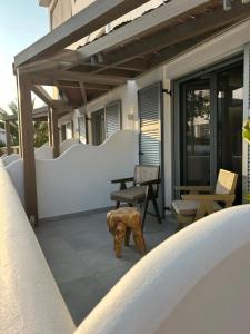 a patio with a table and chairs on a building at G A Suites Maisonettes in Skala in Skala