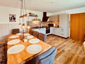 a dining room table with chairs and a kitchen at Ferienhaus mit Whirlpool, Garten und großer Terrasse ruhig privat in Herbstein +32 photos