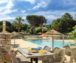 a patio with a table and chairs next to a pool at Cottage PARKS DI LICCIA in Bonifacio +21 photos