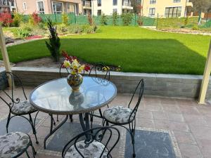 a glass table with chairs and a vase with flowers on it at Villa Belvedere in Varna City