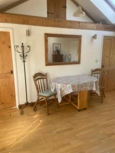 a dining room with a table and a mirror at THE Old DAIRY in Whitland