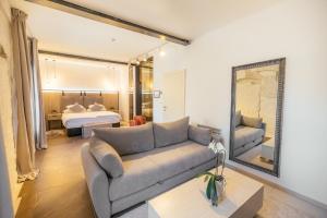 a living room with a couch and a bed and a mirror at VENEZIANA Boutique Hotel Superior in Koper