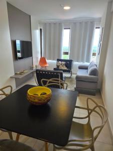 a living room with a table and a couch at Apartamento Fantástico - com estação para carros eletricos in Campina Grande