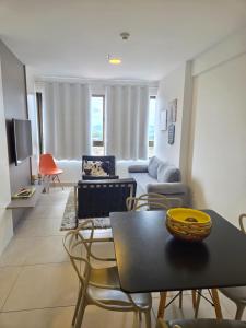 a living room with a table and chairs and a couch at Apartamento Fantástico - com estação para carros eletricos in Campina Grande
