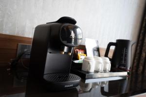 a coffee maker sitting on top of a table at London Court Hotel in London