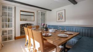 a dining room with a wooden table and chairs at Lower Farmhouse in Todenham