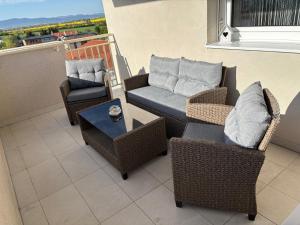 a balcony with chairs and a couch and a table at Lima Apartment in Bernolákovo