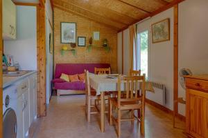 a kitchen and dining room with a table and a couch at Chalet D'alpion Nord avec Piscine in Les Tourrettes