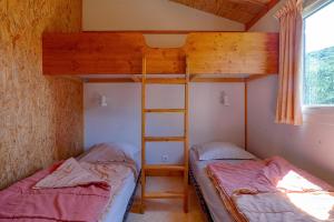 two bunk beds in a room with a window at Chalet D'alpion Nord avec Piscine in Les Tourrettes