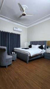 a bedroom with a bed and a ceiling fan at Oasis Family Hotel in Lahore