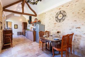 a kitchen and dining room with a table and chairs at La Maisonnette de Marguerite - Avec Climatisation in Vendières