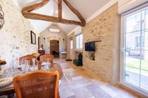 a dining room with a table and a fireplace at La Maisonnette de Marguerite - Avec Climatisation in Vendières