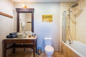 a bathroom with a sink and a toilet and a tub at La Maisonnette de Marguerite - Avec Climatisation in Vendières +4 photos