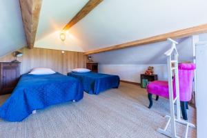 a attic room with two beds and a ladder at La Maisonnette de Marguerite - Avec Climatisation in Vendières