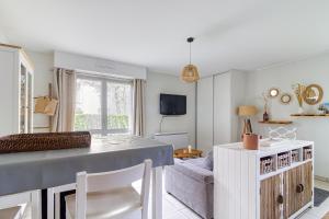 a kitchen and living room with a table and a couch at Entre Dunes et Forêt - Proche Plage in Cucq