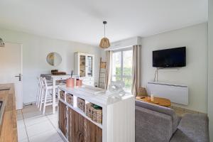a kitchen and living room with a counter and a couch at Entre Dunes et Forêt - Proche Plage in Cucq +8 photos
