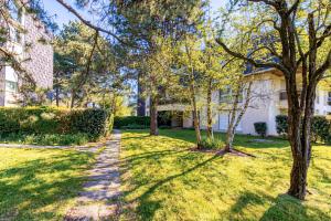 a walkway through a yard with trees and a building at Entre Dunes et Forêt - Proche Plage in Cucq