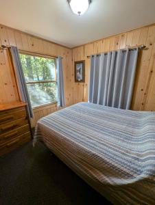 a bedroom with a bed and a window at 2BR 1BA Cabin #7 Riverside Point Resort in Park Rapids