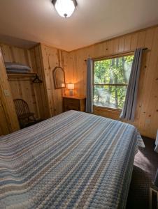 a bedroom with a bed and a window at 2BR 1BA Cabin #7 Riverside Point Resort in Park Rapids +49 photos