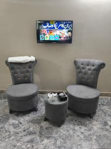 two chairs and a table in a room at Oasis Family Hotel in Lahore +30 photos