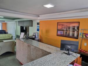 eine Hotellobby mit Rezeption und Fernseher in der Unterkunft Executive Plaza Hotel in Núcleo Bandeirante
