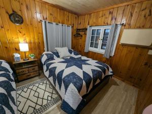 a bedroom with a bed in a wooden room at Cozy Studio Cabin #5 Riverside Point Resort in Park Rapids